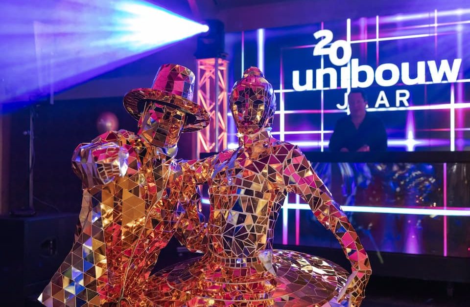 Performers in mirrored costumes at a colourful staff party