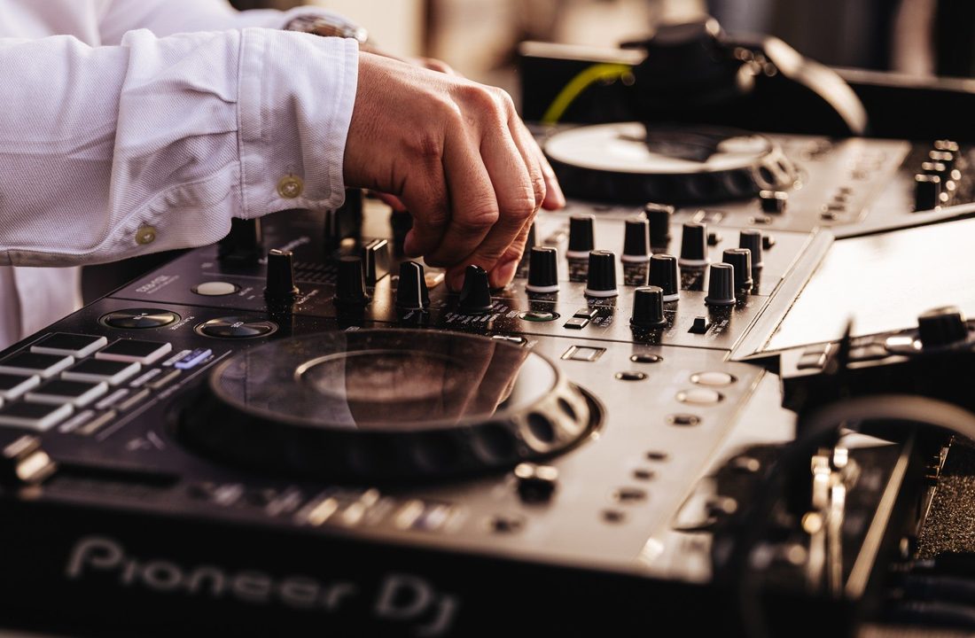 DJ adjusting the controls on professional DJ equipment