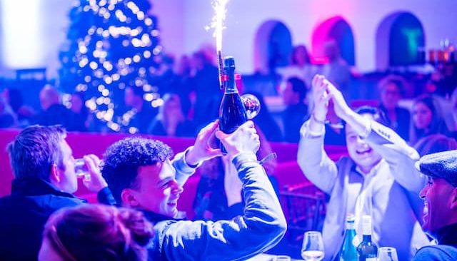Guests celebrating with a sparkling bottle and sparkler during a dinner show