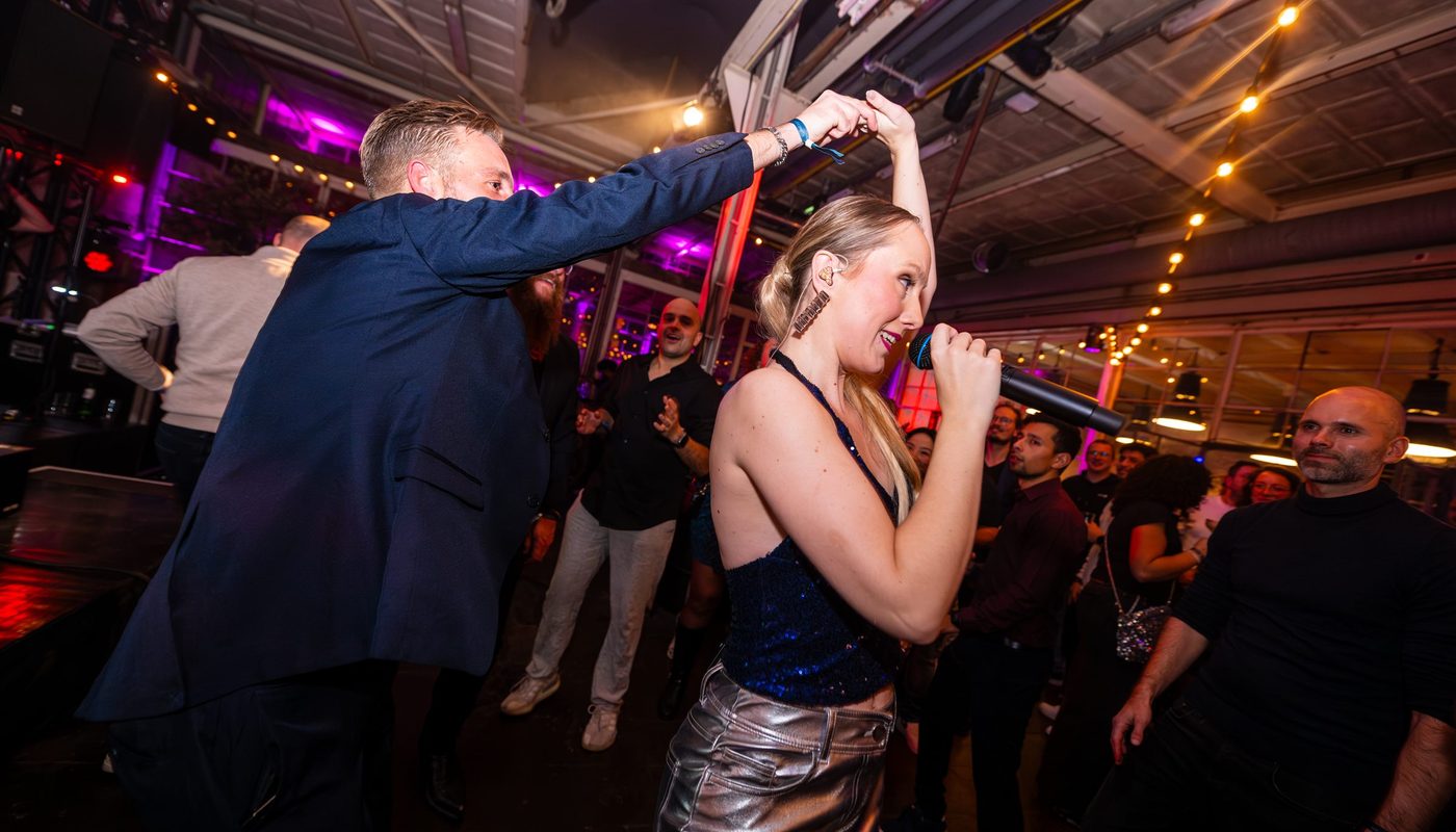 Singer performing among dancing guests during a celebration